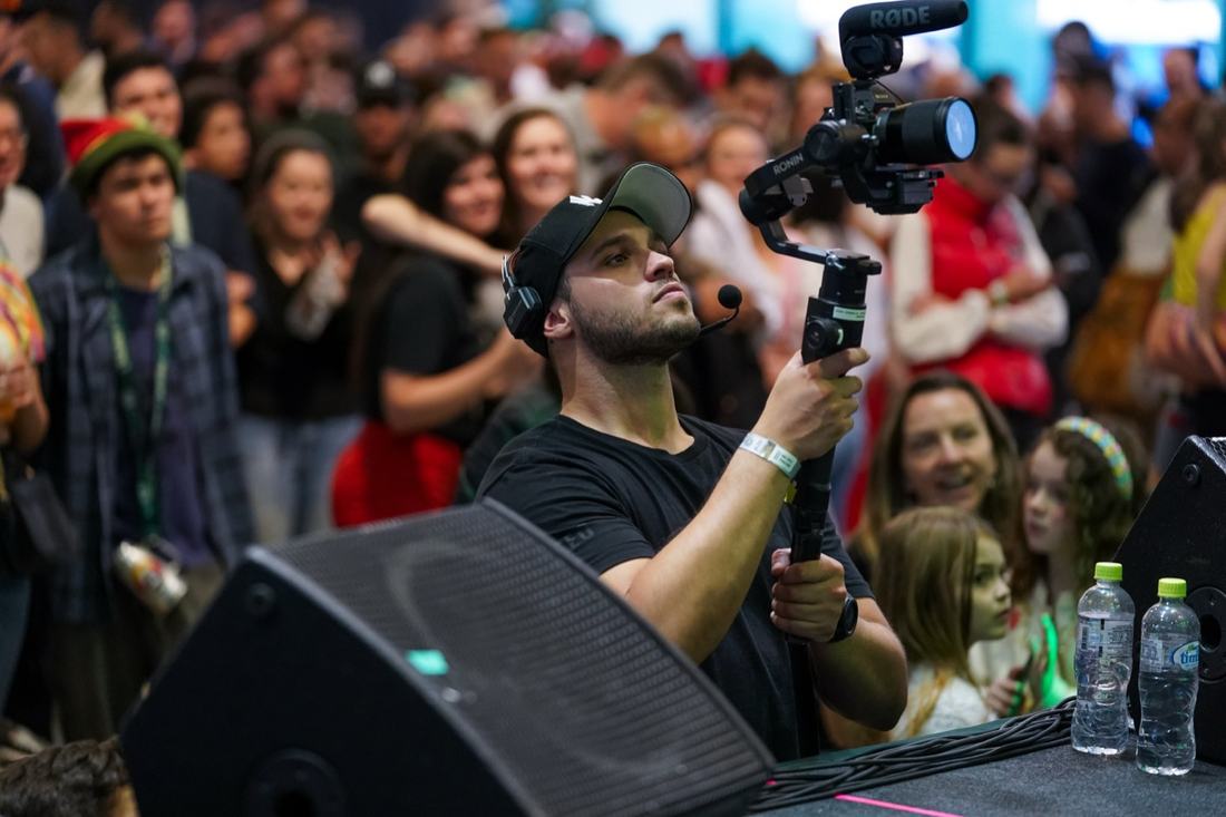 Juan filming the crowd with their arms raised